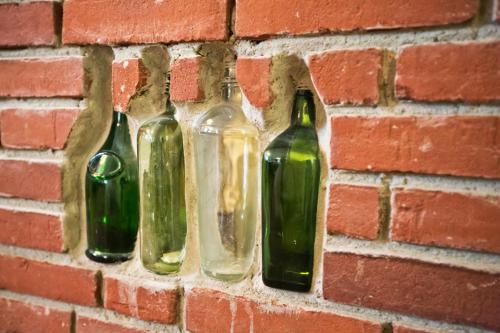 four glass bottles hanging on a brick wall at Hotel Das kleine Glück - Adults Only in Sankt Peter-Ording