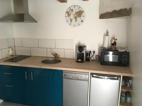 a kitchen with a counter top with a sink and a microwave at Arlequin in Amboise