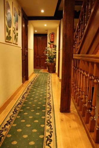 a hallway with a green rug on the floor at Hostería La Antigua in Potes