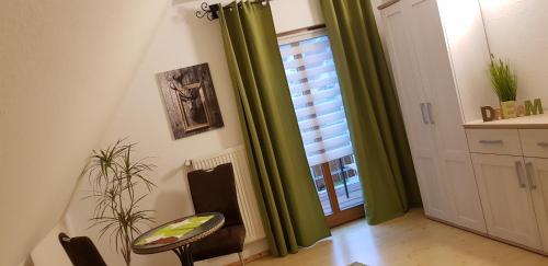 Habitación con cortinas verdes, silla y ventana en Ferienhaus Dorfschmiede en Schönau