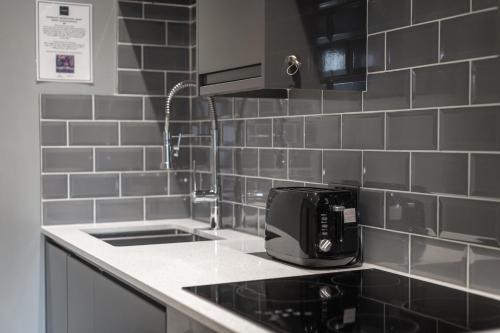 a kitchen with a toaster sitting on a counter at St Benedicts Apartments in Norwich