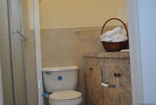 a bathroom with a toilet and a basket of towels at Tropical Hideaway in Nassau