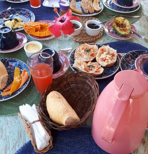 a table topped with plates of food and drinks at Pousada Vila Cacau in Serra Grande