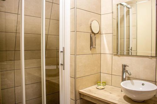 een badkamer met een wastafel en een douche bij Hotel du Port et des Bains in Saint-Valery-sur-Somme