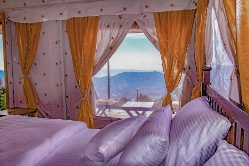 a bedroom with a bed and a window with a view at CBB - Camp Bir Billing in Bīr