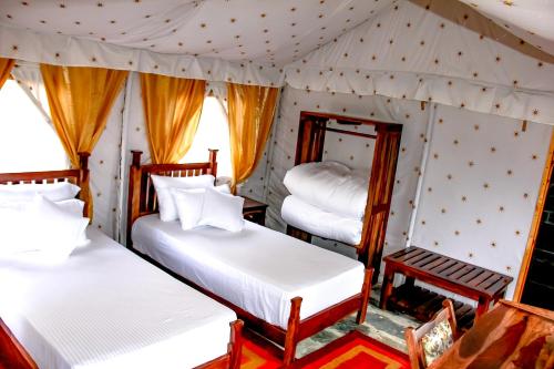 a bedroom with two beds in a tent at CBB - Camp Bir Billing in Bīr