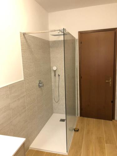 La salle de bains est pourvue d'une douche avec une porte en verre. dans l'établissement Charming Venice 2, à Tessera