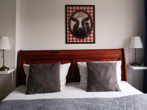 a bed with two pillows and a picture on the wall at Landlust Hotel in Gransee