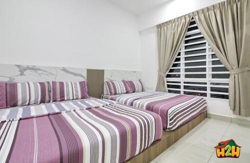 a bedroom with two beds and a window at H2H - Botanical Majestic Ipoh in Ipoh