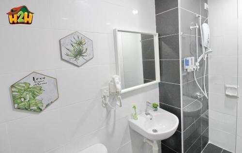 a bathroom with a sink and a toilet and a mirror at H2H - Botanical Majestic Ipoh in Ipoh