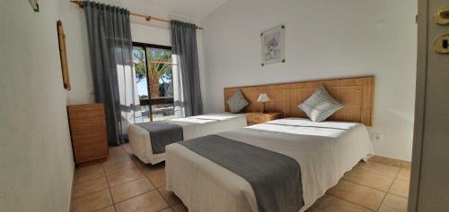 1 dormitorio con 2 camas y ventana en Apartamentos Mar-Bel Sol, en Vilamoura