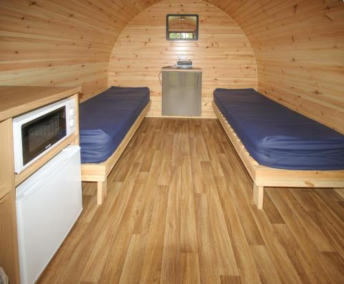a room with two beds in a wooden cabin at Posh Pod in Tyndrum