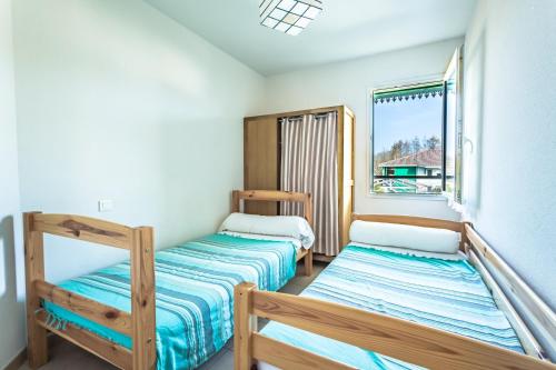 deux lits superposés dans une chambre avec fenêtre dans l'établissement Sanguinet bel appartement 4 à 6 couchages plein centre ville proche commerces et lac, à Sanguinet