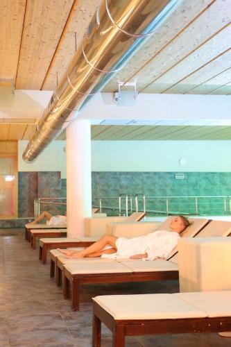 a man laying on a bed in a room at Cocca Hotel Royal Thai Spa in Sarnico