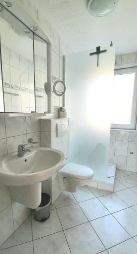 a white bathroom with a sink and a toilet at Sanosueno in Sonthofen