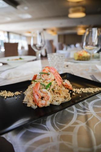 a plate of food with shrimp and noodles on a table at Cocca Hotel Royal Thai Spa in Sarnico