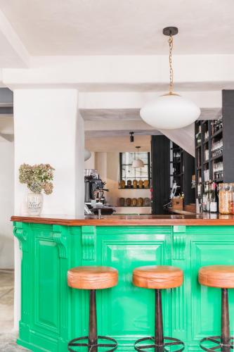 a green bar with wooden stools in a kitchen at The Bull Inn in Totnes