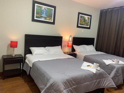 2 camas en una habitación de hotel con 2 lámparas y 2 camas en ORBEGOSO - Trujillo, en Trujillo