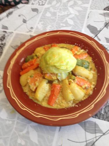a bowl of food with vegetables and sauce on a table at Ferme D"Hote Lala Fatima in Aïn Leuh