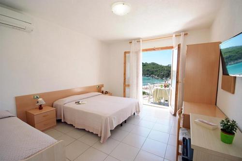 Schlafzimmer mit einem Bett und Meerblick in der Unterkunft Hotel Alma in Campo nell'Elba