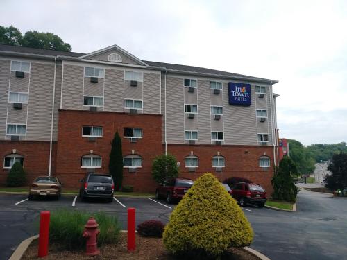 a large building with cars parked in a parking lot at InTown Suites Extended Stay Pittsburgh PA in Pittsburgh
