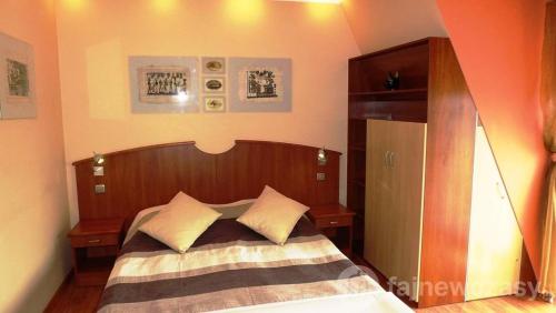 a bedroom with a bed with a wooden head board at DAVIO dla 2 osób in Międzyzdroje
