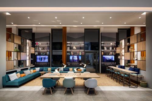 a living room with a couch and a table and chairs at Holiday Inn - Hamburg - HafenCity by IHG in Hamburg