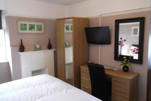 a bedroom with a bed and a desk and a mirror at The Ship Inn in London