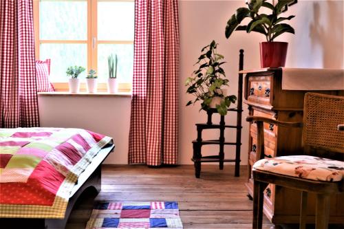 - une chambre avec un lit et une fenêtre ornée de plantes dans l'établissement Höblinghof, à Schwarzau im Gebirge