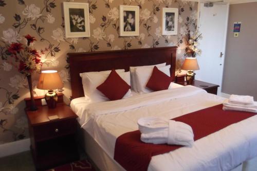 a bedroom with a large bed with two lamps and towels at The Ship Inn in London