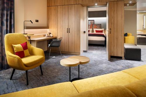 a hotel room with a couch and a bedroom at Holiday Inn - Hamburg - HafenCity by IHG in Hamburg