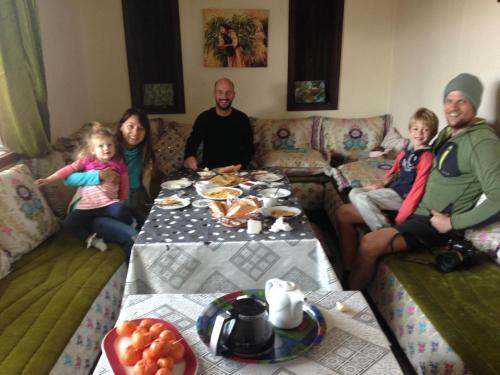 a group of people sitting around a table with food at Ferme D"Hote Lala Fatima in Aïn Leuh
