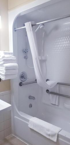 a white bathroom with a bath tub with towels at College Inn in Oxford