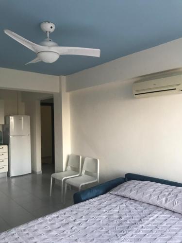 a bedroom with a bed and a ceiling fan at Mazotos 54m2 One Bedroom Flat, "Panoramic Village" in Mazotos