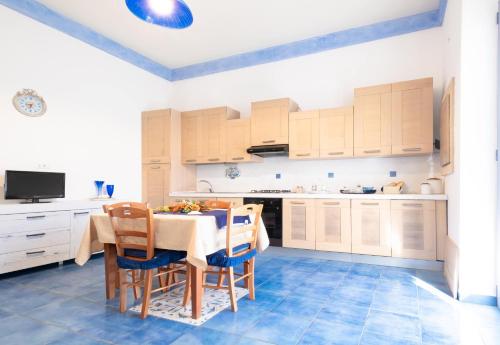 una cucina con tavolo da pranzo e sedie di Luxury Apartments - Torre San Giovanni a Torre San Giovanni Ugento