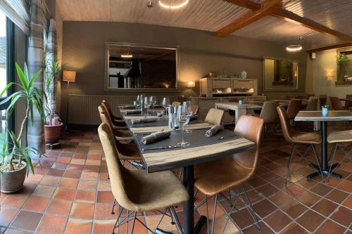 ein Esszimmer mit einem Tisch und Stühlen in einem Restaurant in der Unterkunft Hotel Ulftaler Schenke in Burg-Reuland