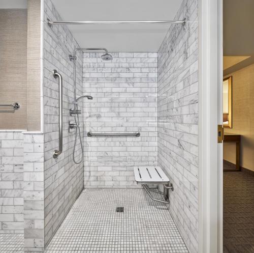eine begehbare Dusche mit einer Bank in einem Badezimmer in der Unterkunft Lord Elgin Hotel in Ottawa