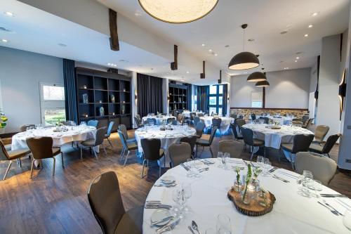 a dining room with white tables and chairs at Bilderberg Kasteel Vaalsbroek in Vaals
