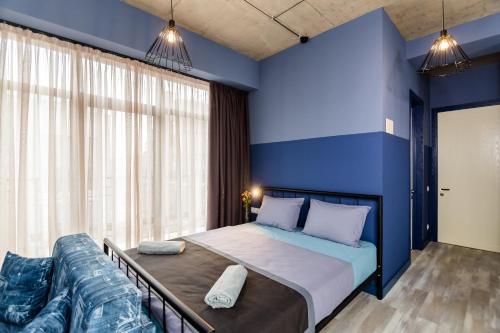 a blue bedroom with a bed and a couch at Modern Avlabari in Old Town in Tbilisi City