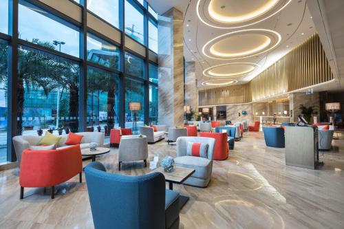 a lobby with chairs and tables and windows at Holiday Inn Shaoguan Downtown by IHG in Shaoguan