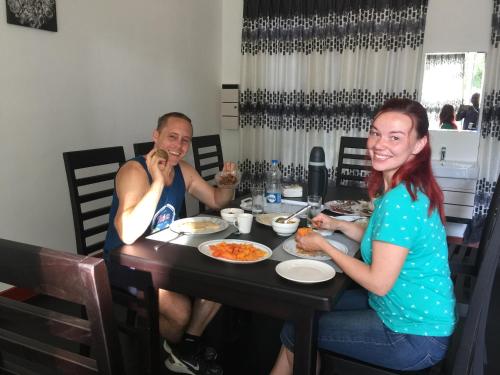 a man and a woman sitting at a table eating food at RoaBaa Guesthouse in Batticaloa