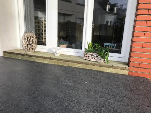 a porch with a window with potted plants on it at la villa du clos avec "spa" in Cayeux-sur-Mer