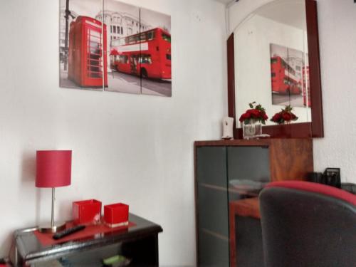 a room with a desk and a red double decker bus at Residence Las Trojes Cdmx in Mexico City