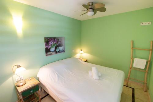 1 dormitorio con cama blanca y pared verde en Seaside Apartment Trupial, en Kralendijk