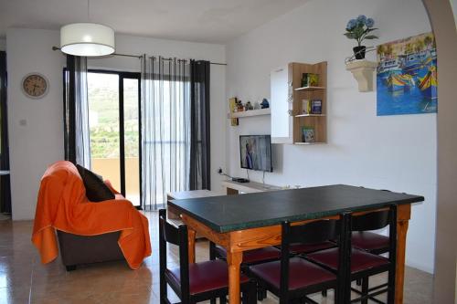 a dining room with a table and a chair at Cesca Apartments - Marsalforn, GOZO in Marsalforn