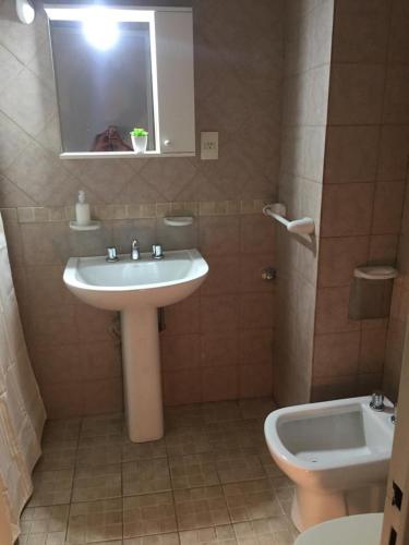 y baño con lavabo, aseo y espejo. en Acogedor monoambiente , en el centro de mendoza . en Mendoza