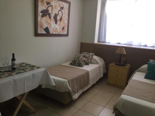 1 dormitorio con 2 camas y una foto en la pared en Acogedor monoambiente , en el centro de mendoza . en Mendoza