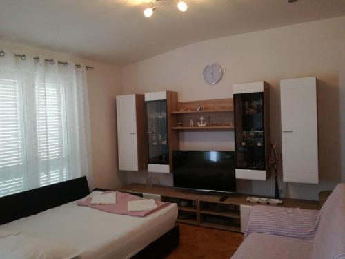 1 dormitorio con 1 cama, TV y armarios en Apartments Ćulav, en Makarska
