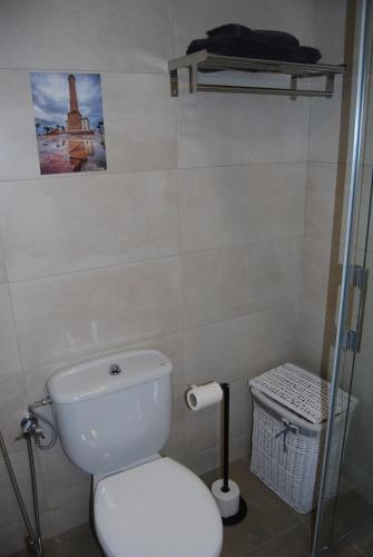 a bathroom with a toilet and a picture on the wall at La casa De Los Faros in El Puerto de Santa María