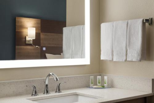 a bathroom with a sink and a mirror and towels at AmericInn by Wyndham Dodgeville in Dodgeville